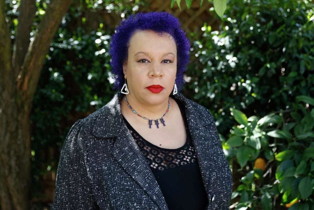 A woman with purple hair and a black shirt.