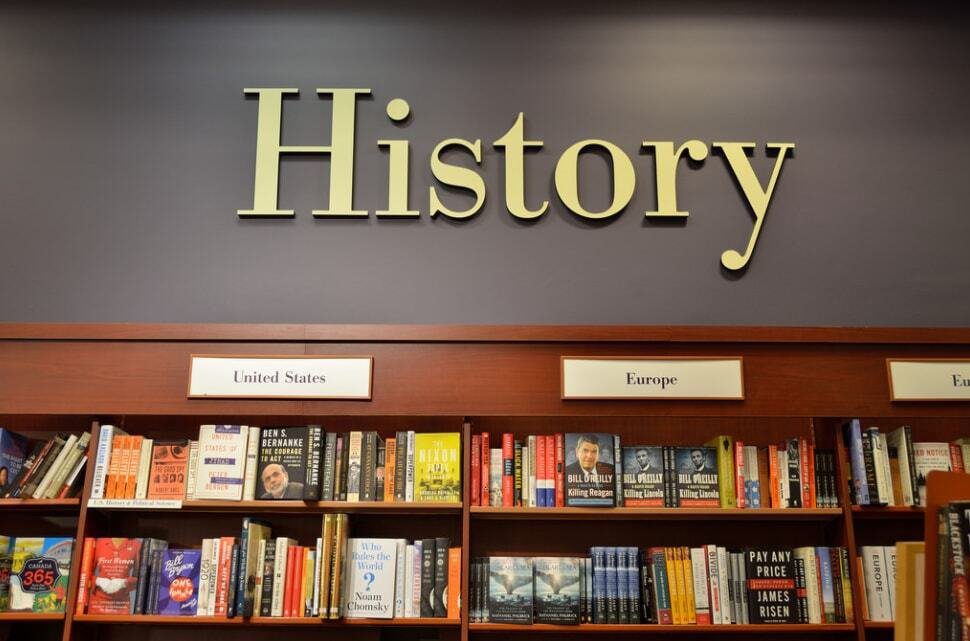 Bookshelf in a library labeled "history" with sections for united states and europe, filled with various history books.