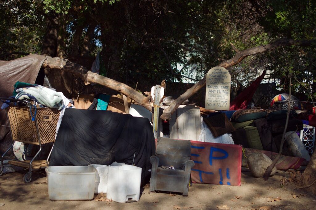 Homeless encampment with sign asking for respect.