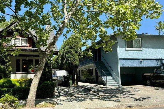 Two homes with a tree in the foreground.