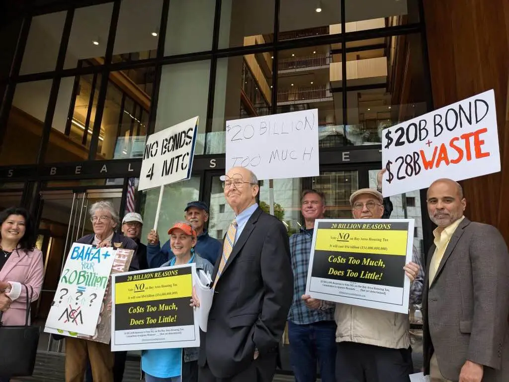 Protesters holding signs against a bond.