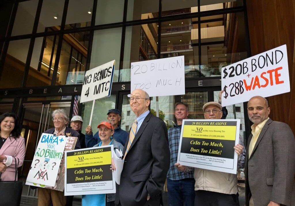 Protesters holding signs against a bond.