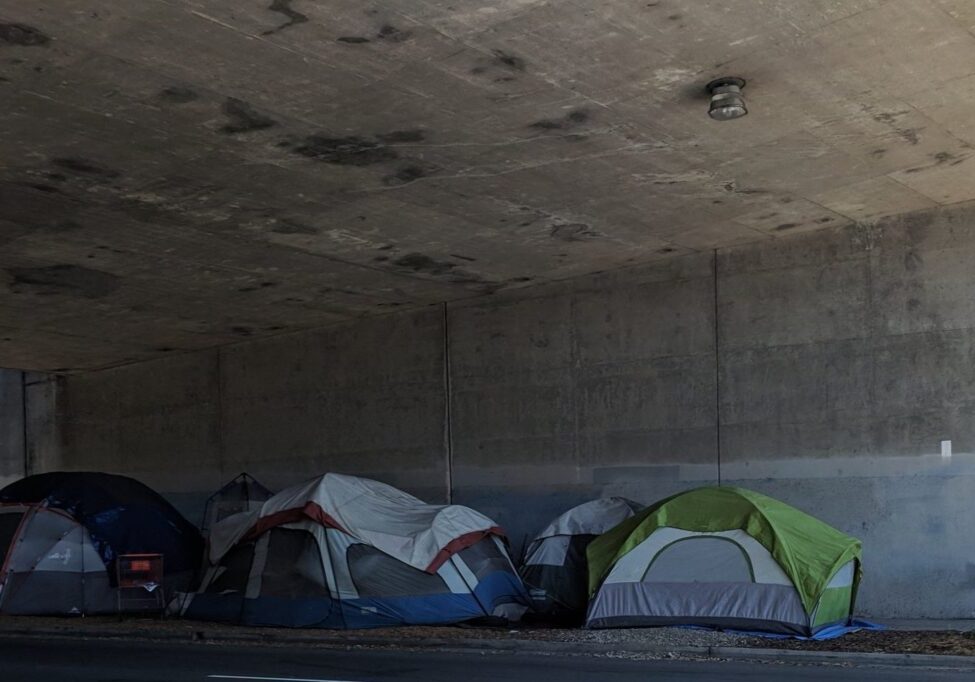 Tents under concrete overpass.