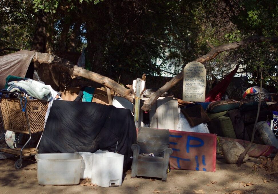 Homeless encampment with sign asking for respect.