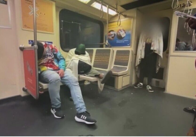 Two men sitting on a subway train.