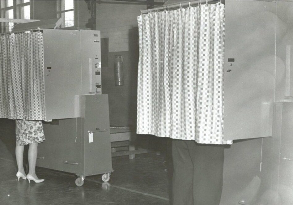 Two voting booths with curtains drawn.