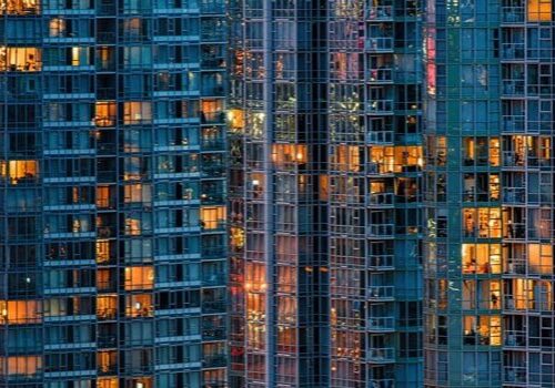 Modern glass building with lit windows.